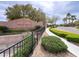 An inviting community entrance featuring lush landscaping and a decorative brick wall and signage at 6392 Ebony Legends Ave, Las Vegas, NV 89131