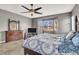 Well-lit main bedroom with a ceiling fan, dark wood furniture, and a large window at 6392 Ebony Legends Ave, Las Vegas, NV 89131