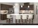 Modern kitchen with dark cabinetry, stainless steel appliances, and a large center island with white countertop and seating at 6818 Sweet Bay St # Lot 11, Las Vegas, NV 89166