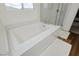 Bright bathroom featuring a white soaking tub and a separate glass shower at 683 Quasi St, Henderson, NV 89011