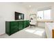 Sunlit bedroom showcasing a green dresser, white rocking chair, and natural light from the window at 683 Quasi St, Henderson, NV 89011
