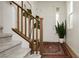 Foyer features a patterned rug, a wooden banister staircase, and decoratively placed plants at 683 Quasi St, Henderson, NV 89011