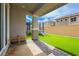 Inviting covered patio with pavers, exterior bench, artificial turf, and block perimeter wall at 683 Quasi St, Henderson, NV 89011