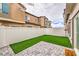 Fenced backyard featuring artificial grass and a stone patio with view of the surrounding homes at 7232 N Decatur Blvd # 4, Las Vegas, NV 89131