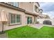 Backyard with artificial grass, a patio, and a view of the home's exterior and surrounding neighborhood at 7232 N Decatur Blvd # 4, Las Vegas, NV 89131