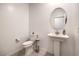 Powder room featuring a pedestal sink, toilet, neutral paint and modern fixtures at 7232 N Decatur Blvd # 4, Las Vegas, NV 89131