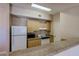 A functional kitchen with white appliances, light wood cabinets and granite countertops at 8000 W Badura Ave # 1130, Las Vegas, NV 89113