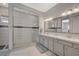 Bathroom featuring double sink vanity, walk-in shower with glass door and decorative tile accent at 8525 Stokestone St, Las Vegas, NV 89166