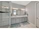 Bathroom featuring double sink vanity, walk-in shower with glass door and decorative tile accent at 8525 Stokestone St, Las Vegas, NV 89166