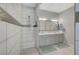 Bathroom featuring double sink vanity, walk-in shower with glass door and decorative tile accent at 8525 Stokestone St, Las Vegas, NV 89166