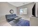 This bonus bedroom is a relaxing space with a blue futon, large window and sleek media cabinet at 8525 Stokestone St, Las Vegas, NV 89166