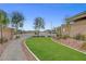Neighborhood common area features green lawn, trees, stone landscape, and sidewalks at 8525 Stokestone St, Las Vegas, NV 89166