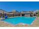 A sunny community pool with lounge chairs, umbrellas, and a pool house for residents at 8525 Stokestone St, Las Vegas, NV 89166