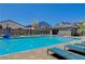 A refreshing community pool with shallow depths, lounge chairs, and covered seating areas at 8525 Stokestone St, Las Vegas, NV 89166