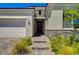 Inviting home entrance featuring a brick pathway, stone accents, and a well-maintained two car garage at 8525 Stokestone St, Las Vegas, NV 89166