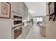 Long kitchen view featuring stainless appliances and a view into an open living space at 8525 Stokestone St, Las Vegas, NV 89166