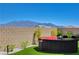 A shaded backyard seating area features a conversation set with a view of mountains in the distance at 8525 Stokestone St, Las Vegas, NV 89166