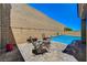 The backyard features a pool with lounge seating and a high privacy wall at 8525 Stokestone St, Las Vegas, NV 89166