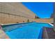 Sparkling pool with a stacked-stone wall creating a private, resort-like backyard oasis at 8525 Stokestone St, Las Vegas, NV 89166