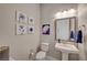 Elegant half-bathroom with pedestal sink, decorative mirror and stylish artwork at 8525 Stokestone St, Las Vegas, NV 89166