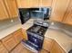 Kitchen with stainless steel stove and microwave and wooden cabinetry at 8777 W Maule Ave # 2167, Las Vegas, NV 89148