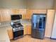 Kitchen featuring stainless steel appliances, light wood cabinets, and attractive wood-look floors at 8777 W Maule Ave # 2167, Las Vegas, NV 89148