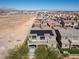 An aerial view showcasing the property, solar panels, pool, and backyard with desert landscape at 8895 Dartmouth Grove Ave, Las Vegas, NV 89148