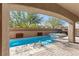Inviting outdoor space with a covered patio overlooking a sleek pool and a lush landscaped yard at 8895 Dartmouth Grove Ave, Las Vegas, NV 89148