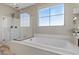 Bright bathroom with a glass-enclosed shower and a soaking tub under a window at 8895 Dartmouth Grove Ave, Las Vegas, NV 89148