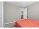 A minimalist bedroom features an orange comforter and simple decor at 8895 Dartmouth Grove Ave, Las Vegas, NV 89148