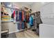 Organized walk-in closet with ample storage shelves, hanging rods, and a stacked washer/dryer at 8895 Dartmouth Grove Ave, Las Vegas, NV 89148