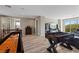 Spacious game room featuring a foosball table, shuffleboard and natural light from sliding glass doors at 8895 Dartmouth Grove Ave, Las Vegas, NV 89148