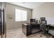 Well-lit home office with a large desk, ergonomic chair and a window providing natural light at 8895 Dartmouth Grove Ave, Las Vegas, NV 89148