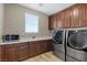Laundry room with washer, dryer, and built-in cabinets above a sink at 8895 Dartmouth Grove Ave, Las Vegas, NV 89148