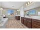 Bright main bathroom features a soaking tub, double vanities, and a large window with neighborhood views at 8895 Dartmouth Grove Ave, Las Vegas, NV 89148