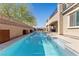 Backyard view of a sparkling lap pool surrounded by lush landscaping and a contemporary hardscape at 8895 Dartmouth Grove Ave, Las Vegas, NV 89148