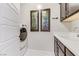 Bright laundry room with white cabinets and stainless steel washing machine at 8992 Sparkling River Ct, Las Vegas, NV 89178