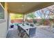 Covered patio with outdoor dining set, desert landscaping, and brick pavers at 8992 Sparkling River Ct, Las Vegas, NV 89178