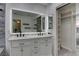 Modern bathroom featuring a double sink vanity, large mirror, and open closet with shelving at 9680 Granite Gorge Ct, Las Vegas, NV 89148