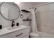 Bathroom with a shower-tub combo, black fixtures and a round mirror over a modern vanity at 9680 Granite Gorge Ct, Las Vegas, NV 89148