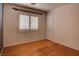 Bedroom with wood flooring, window with blinds and a white door leading to the hall at 9680 Granite Gorge Ct, Las Vegas, NV 89148