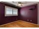 A purple bedroom with hardwood floors, window with blinds and a ceiling fan with lighting at 9680 Granite Gorge Ct, Las Vegas, NV 89148