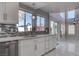 View of the kitchen sink, white cabinets, and bright windows, with a view to the living room at 9680 Granite Gorge Ct, Las Vegas, NV 89148