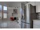 Open kitchen with stainless steel refrigerator, white cabinetry, and a view of the living room at 9680 Granite Gorge Ct, Las Vegas, NV 89148