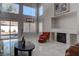 Elegant living area with fireplace, tile flooring, tall windows, and backyard views at 9680 Granite Gorge Ct, Las Vegas, NV 89148