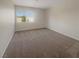 This bedroom has a large window, neutral paint and carpet at 9885 Ramhorn Canyon St, Las Vegas, NV 89183