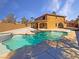 Backyard pool with a baja step and outdoor living space at 9885 Ramhorn Canyon St, Las Vegas, NV 89183