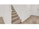 Carpeted stairs lead to the upper level, with laminate floors on the main floor at 9920 Keephills St, Las Vegas, NV 89183