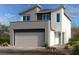 Modern two-story home with a two-car garage and contemporary architectural details, complemented by desert landscaping at 10012 River Corral St, Las Vegas, NV 89166
