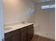 Main bath featuring double sinks, brown cabinets, quartz countertops, and a walk-in shower at 10012 River Corral St, Las Vegas, NV 89166